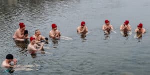 People swim in icy river